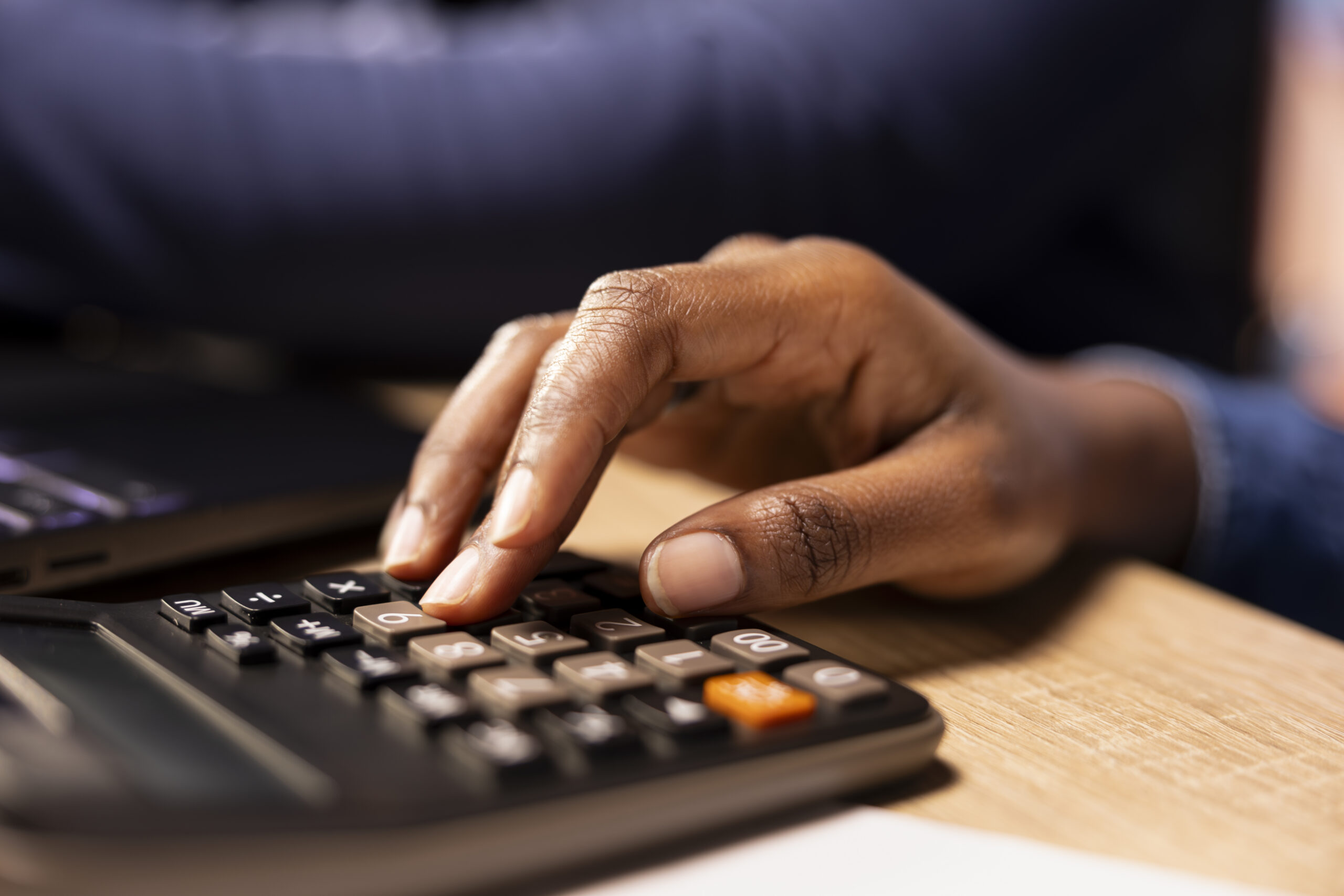 African American hand using a calculator.